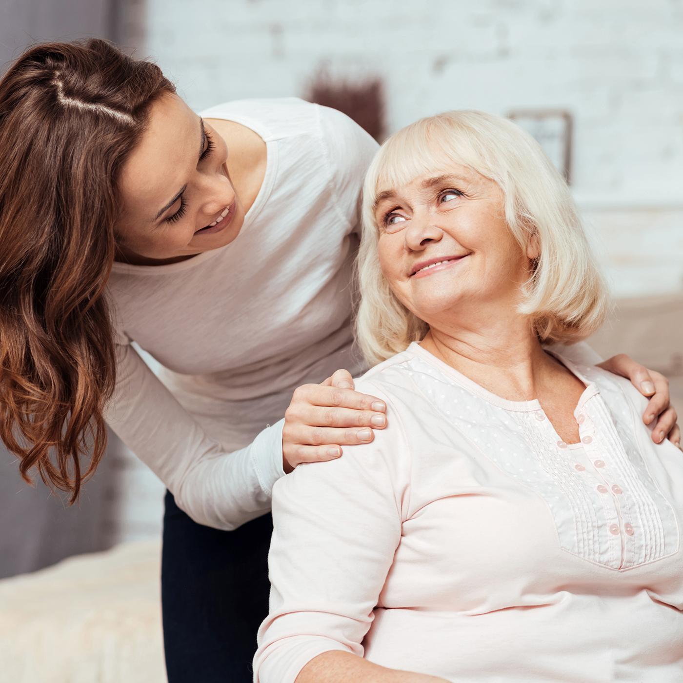 Cheerful woman taking care of her grandmother in wheelchair