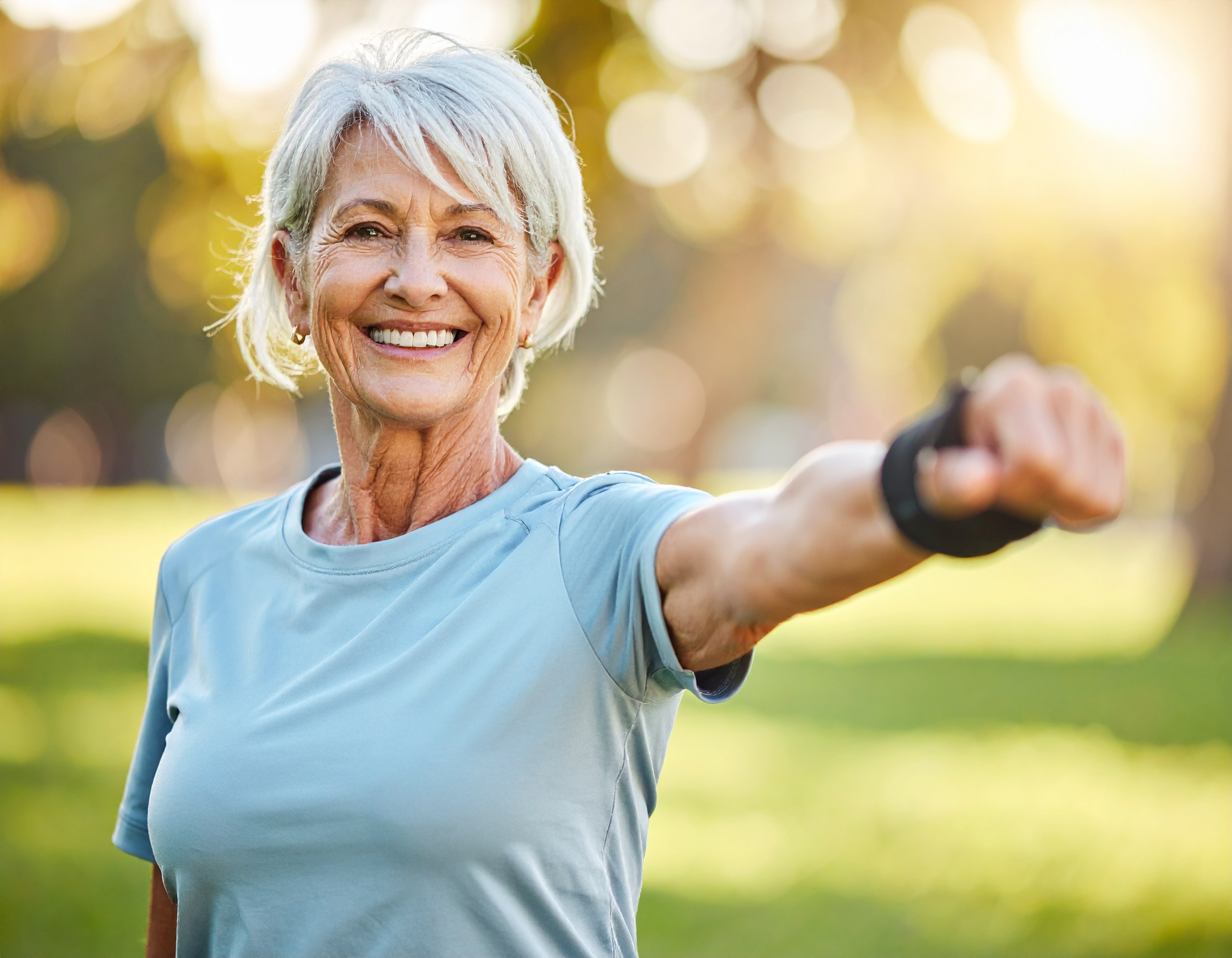 Firefly_Laurence, 68 ans, fait des étirements doux dans un parc, sourire aux lèvres, avec une 728547