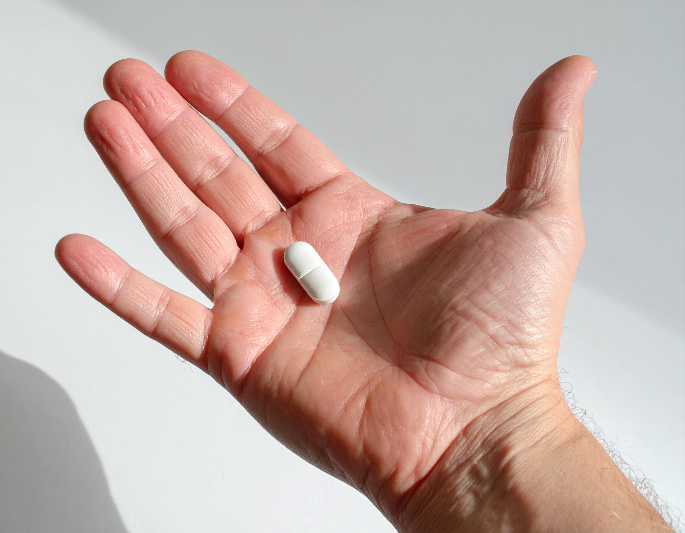 Firefly_Une main caucasienne, 50 ans, tenant un paracétamol, est le sujet principal. La main 832319