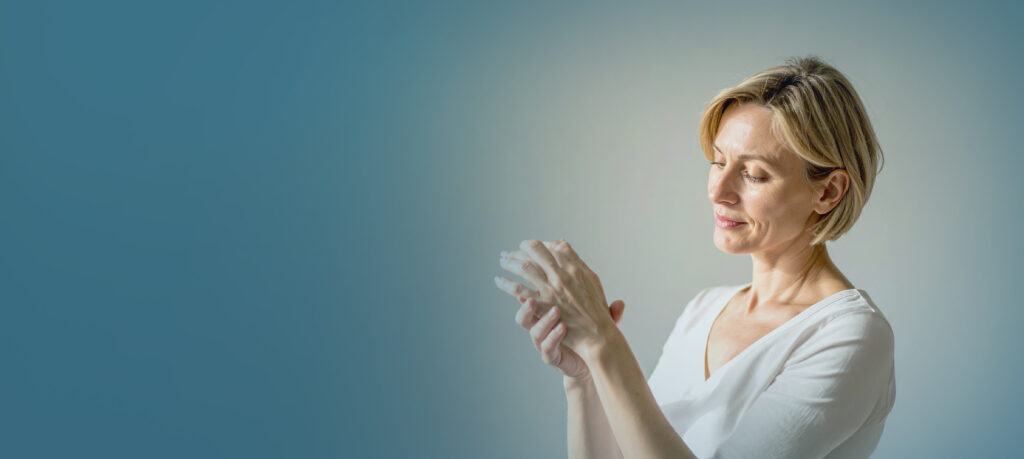 a man has pain in his thumb Deux mains âgées se touchent doucement.