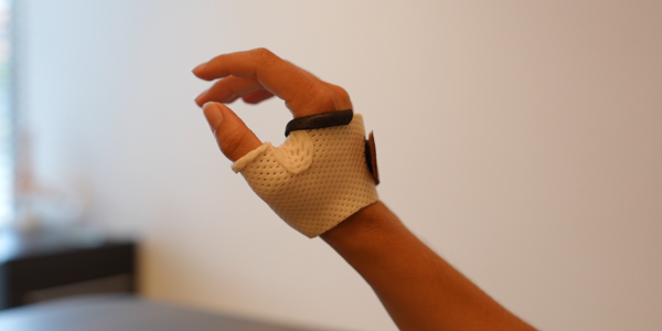 Main avec un gant de rééducation.