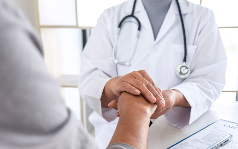Médecin tenant la main d'un patient.