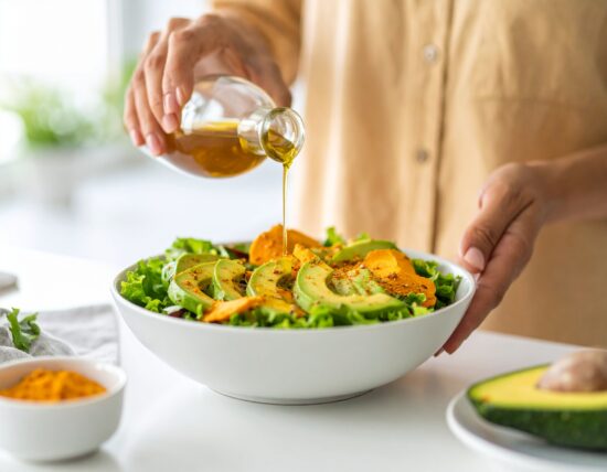 Gesunder Salat mit Avocado und Öl übergossen.