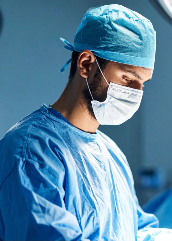 Chirurgo in azione con mascherina e abbigliamento sterile