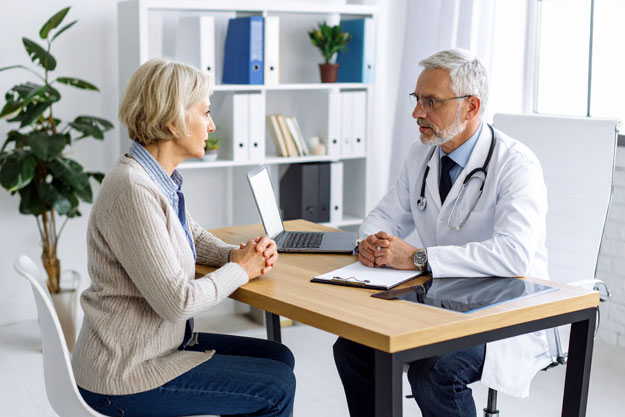 Consultazione tra medico e paziente anziana.